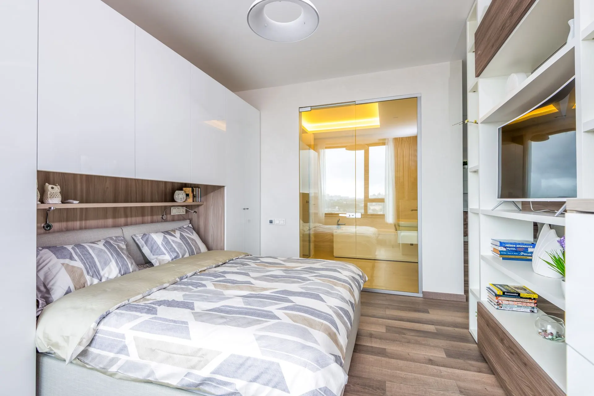 Vedere de ansamblu a dormitorului de studio, cu mobilier deschis la culoare