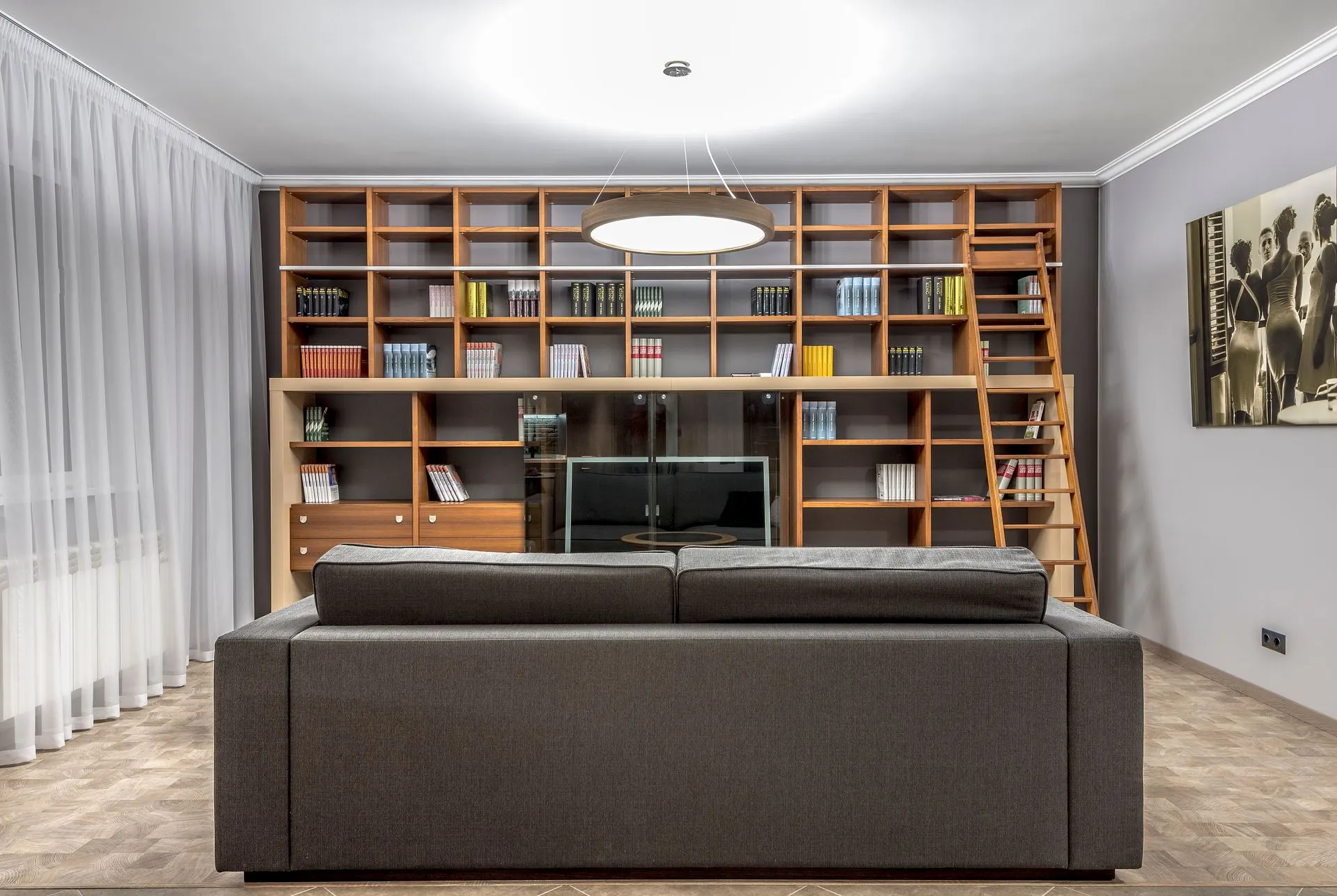 Bibliotecă înaltă lângă un fotoliu, într-un colț de lectură